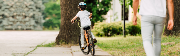 панорамный вид на ребенка на велосипеде во время прогулки отца за сыном
 - Фото, изображение