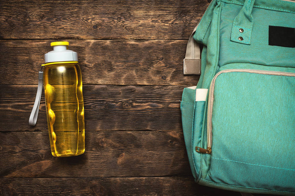 Sport flat lay background with a copy space. A backpack and yellow bottle of water. - Фото, зображення