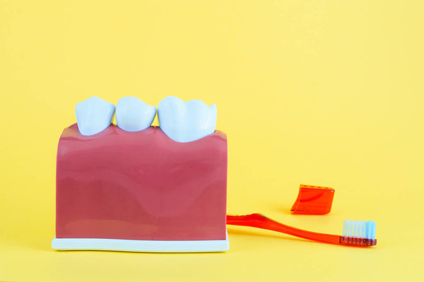 falscher Mund auf gelbem Hintergrund mit Zahnbürste - Foto, Bild