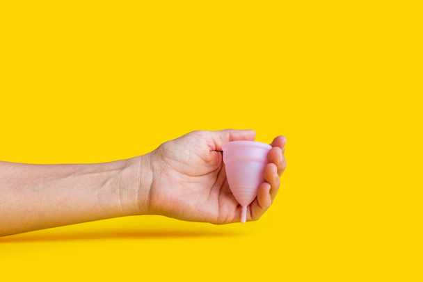 Woman hand holding pink menstrual cup. Zero waste - Foto, Imagem