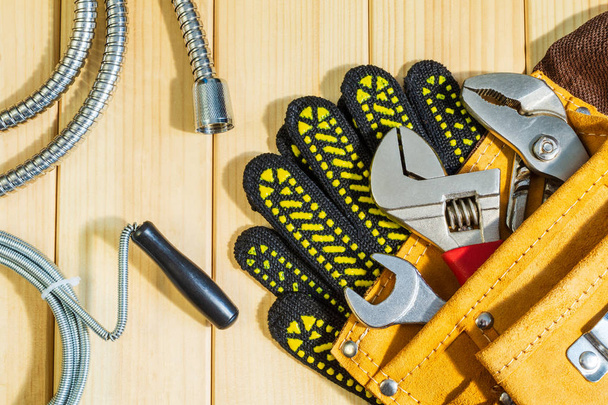 Necessary set of tools in the bag for plumbers on a wooden background. - Photo, Image
