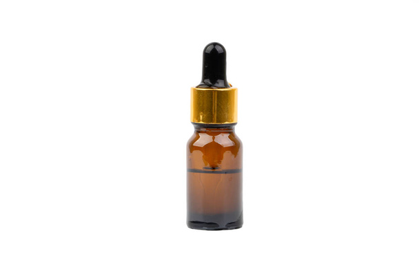 Druppelaar serum en bruine glazen fles geïsoleerd op witte achtergrond. Huidverzorging, drugs-en cosmetisch concept - Foto, afbeelding