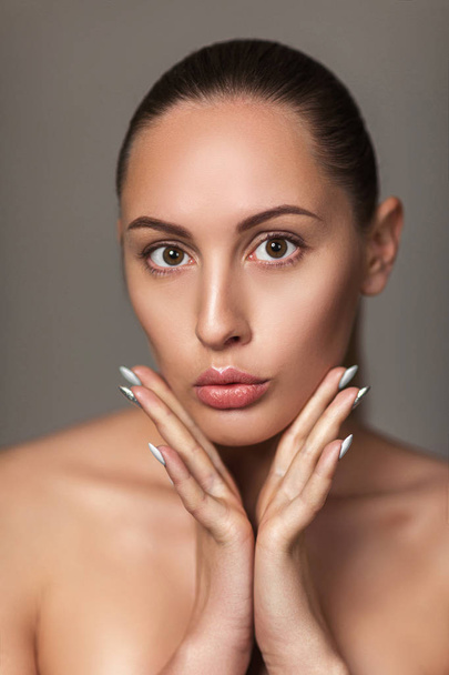 beautiful woman touch own face. model with light nude make-up - Фото, зображення