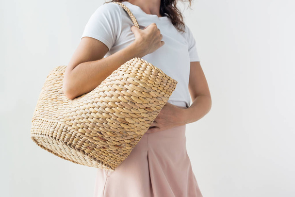 Fashionable stylish woman holding straw rattan bag - Фото, изображение