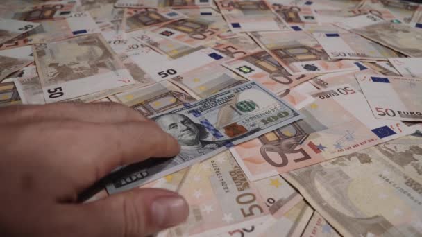 POV playing with a 100 dollar note. Rows of 50 euro notes on the background - Footage, Video