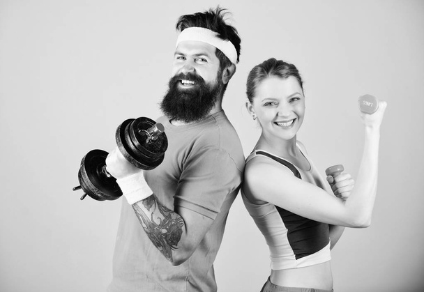 Man and woman exercising with dumbbells. Fitness exercises with dumbbells. Workout with dumbbells. Girl and guy hold dumbbells. Fitness sport exercises. Sporty family. Healthy lifestyle concept - Photo, Image