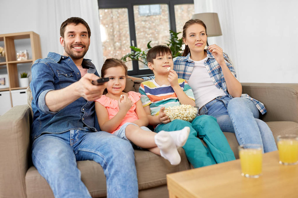 happy family with popcorn watching tv at home - Foto, Bild