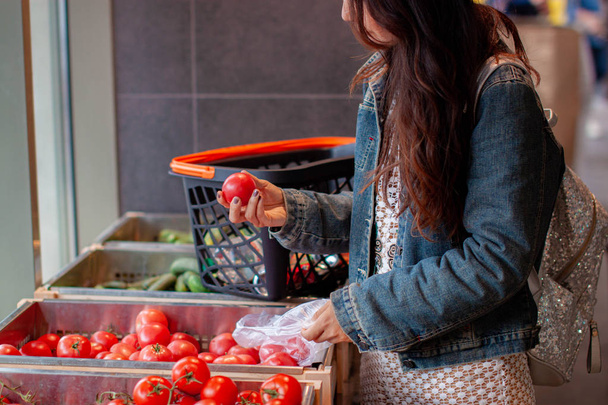 nainen ostamassa hedelmiä ja vihanneksia päivittäistavarakaupan / supermarketin tuoteosastolla
 - Valokuva, kuva