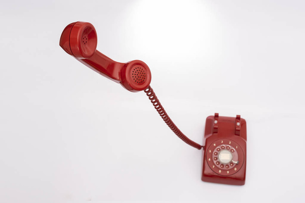 Teléfono rojo fijo retro sobre un fondo blanco aislado
 - Foto, imagen