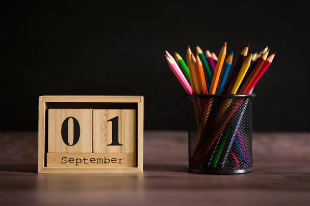 Glasses stand with pencils on table, on background of blackboard with chalk. Concept of teachers day. Copy space. - Photo, Image