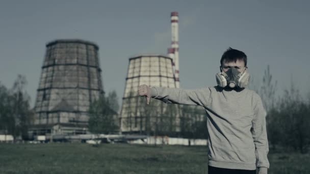 protest tegen luchtverontreiniging. Jonge kerel toont de vinger naar beneden tegen de fabrieks schoorstenen. Tiener vertoont afkeer omdat milieuproblemen. - Video