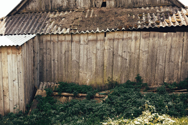 Piękny stary drewniany domek z zieloną trawą. W wieku drewniany mur - Zdjęcie, obraz