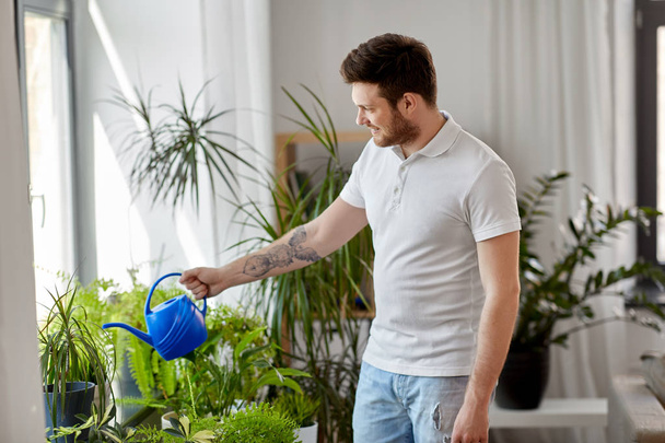 man watering houseplants at home - 写真・画像