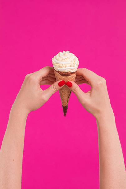 Female hand holding ice cream in waffle cone - Zdjęcie, obraz