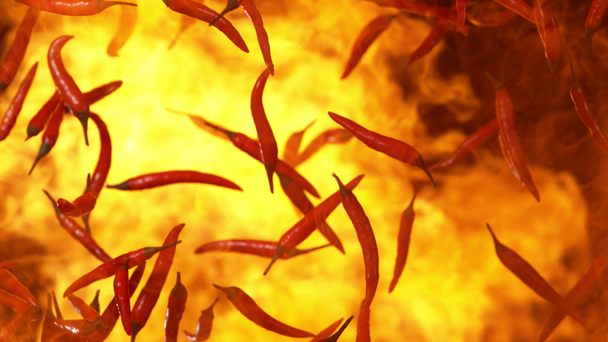 Super powolny ruch latające czerwone gorące papryki chilli w ogniu. Nakręcony na wysokiej prędkości kamery kinowej, 1000 FPS - Materiał filmowy, wideo
