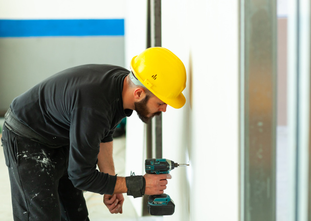 Εργαζόμενος χτίζει ένα τοίχωμα γυψοσανίδας. - Φωτογραφία, εικόνα