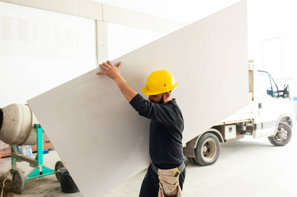 Worker builds a plasterboard wall. - Zdjęcie, obraz