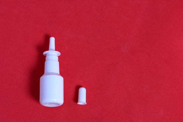Nasal spray. Against the background of coral color. View from above. - 写真・画像