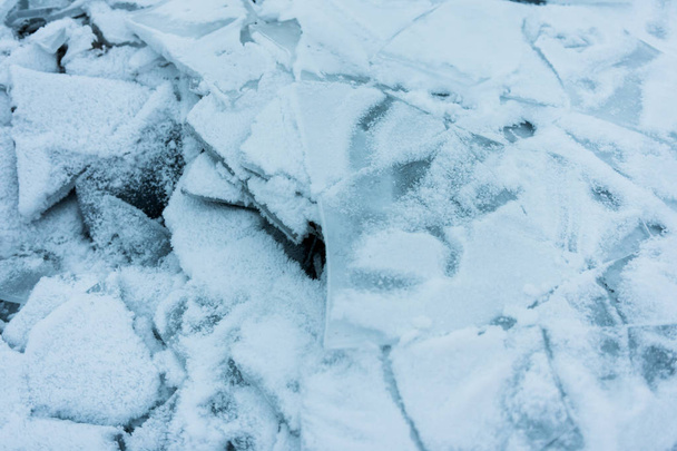 凍った湖のほとりにあるひび割れた氷の破片 - 写真・画像