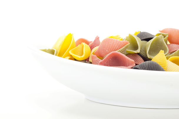Coloridos fideos de concha italianos en plato blanco
 - Foto, imagen