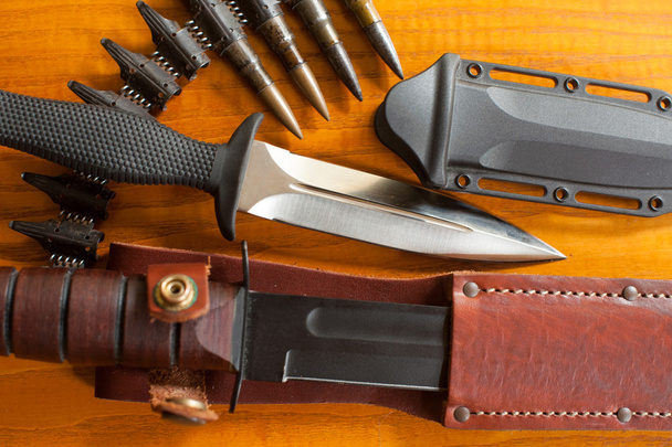 Military knives and scabbard isolated on the wooden background - Foto, imagen