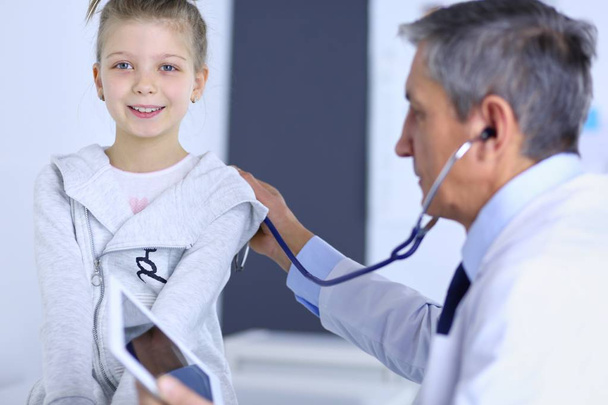 Girl and doctor with stethoscope listening to heartbeat - 写真・画像