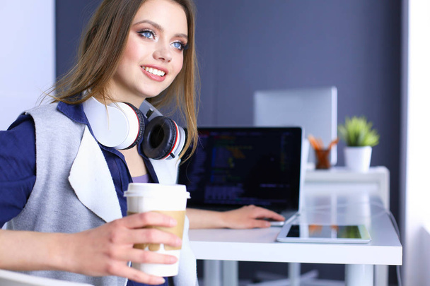 Joven mujer feliz hablando en el teléfono móvil mientras está sentado con una taza de café
 - Foto, Imagen