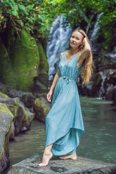 Woman traveler on a waterfall background. Ecotourism concept - Photo, Image