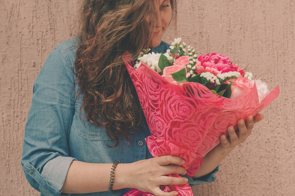 happy young woman in denim dress with bouquet of gentle fresh flowers - Φωτογραφία, εικόνα