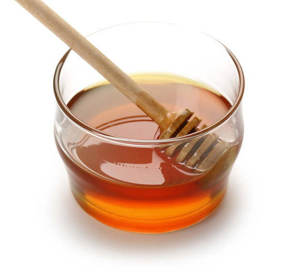 Honey with wooden dipper in glass bowl isolated - Foto, afbeelding