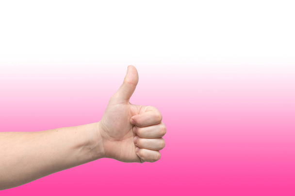 Gros plan de la main masculine montrant les pouces vers le haut signe sur fond de gradient rose
 - Photo, image