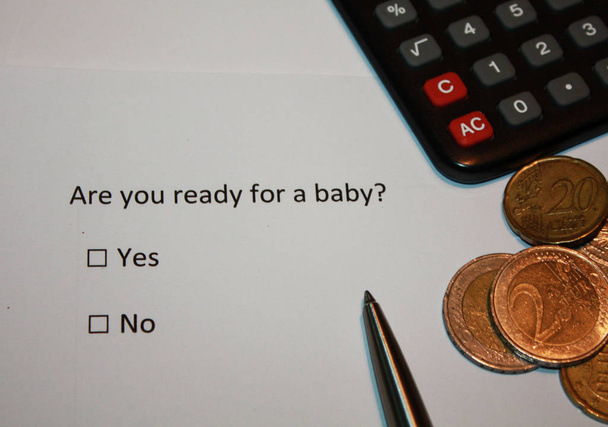 アンケートの質問を持つ紙:あなたは赤ちゃんのための準備ができていますか?はいまたはいいえボックスとユーロコインと電卓。責任ある親の計画テーマ写真. - 写真・画像