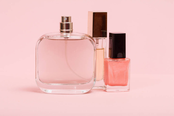 Жіночі парфуми та косметика на рожевому тлі
. - Фото, зображення