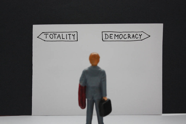 Totality versus demokrácia lehetőségek nyilakkal guidepost. Két lehetőség és a kis ember dönt róla, a szabadság vagy elnyomása. - Fotó, kép