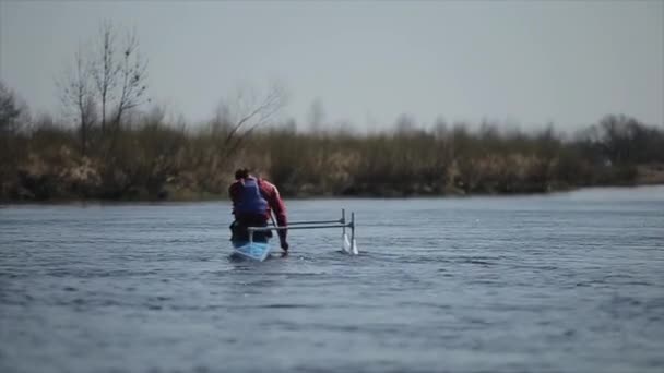 Achteraanzicht van gehandicapte sportman Roeien op de rivier in een kano. Roeien, kanoën, peddelen. Opleiding. Kajakken. paraolympic sport. kano voor gehandicapten. - Video