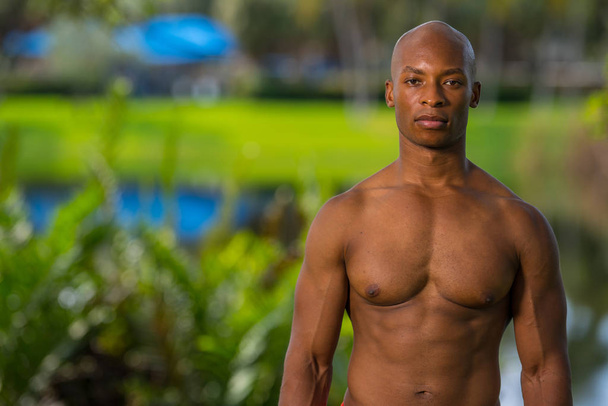 Portrait of a ripped body muscle man posing outdoors in the park - Photo, Image