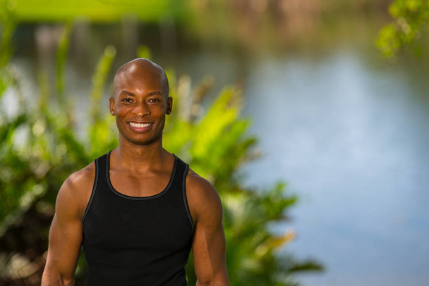 Muotokuva hymyilevä Afrikkalainen Amerikkalainen kunto malli poseeraa ulkona
  - Valokuva, kuva