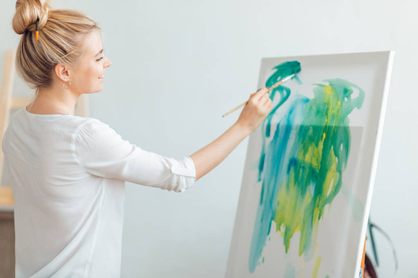 young awesome good looking girl in white blouse creating art - 写真・画像