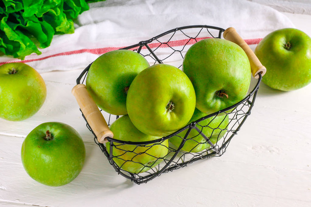 Vihreitä omenoita metallikorissa valkoisella pohjalla. Luonnollinen ravinto, tuoreita hedelmiä. Dieetti
. - Valokuva, kuva