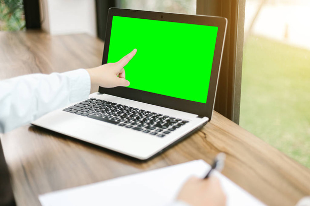 Close-up of business female working pointing at her laptop and make a note in coffee shop like the background,green screen. - Foto, imagen