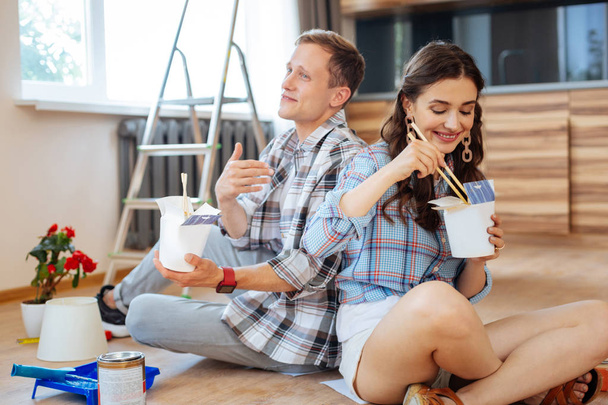 Husband wearing smart watch eating noodles with wife - Zdjęcie, obraz