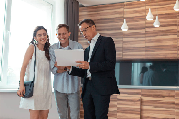 Couple feeling excited while speaking with real estate agent - Valokuva, kuva