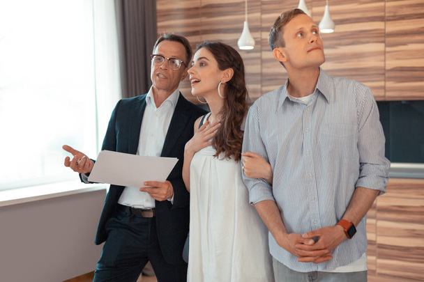 Woman listening to realtor while standing near husband - Photo, Image