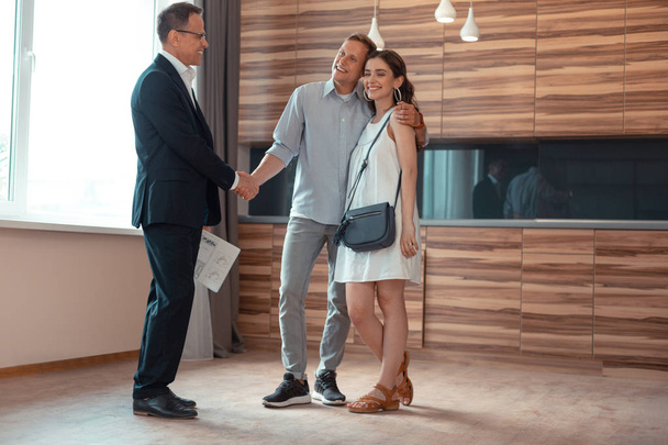 Realtor shaking hand of clients buying the house - Photo, Image