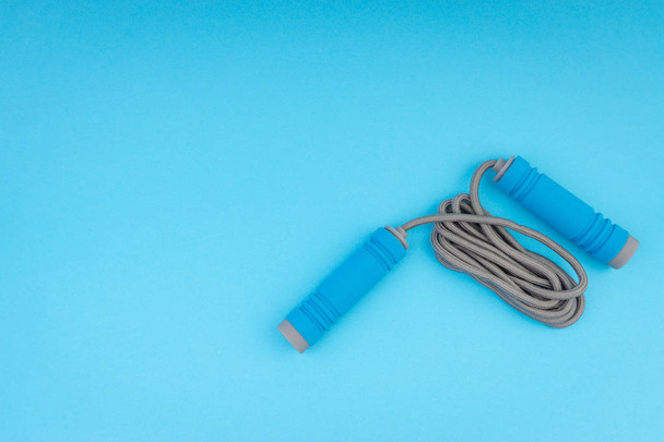 Corda per saltare o corda per saltare isolata su sfondo blu. Focus selettivo e frammento di coltura
 - Foto, immagini