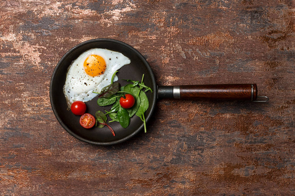 Pan with fried egg, cherry tomatoes and herbs - Valokuva, kuva