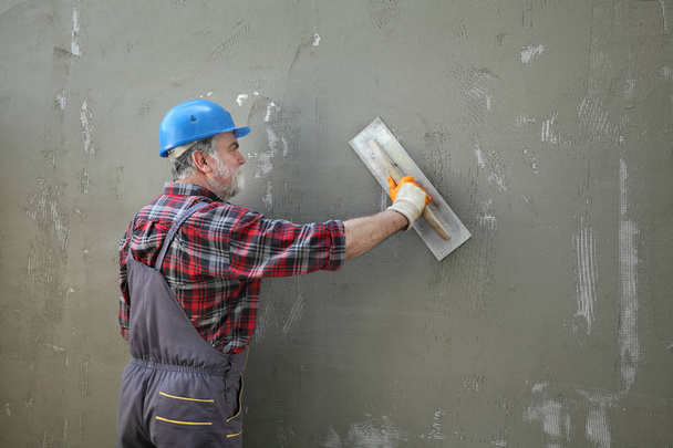 Wall insulation, spreading mortar over mesh and styrofoam, polys - Foto, Imagen