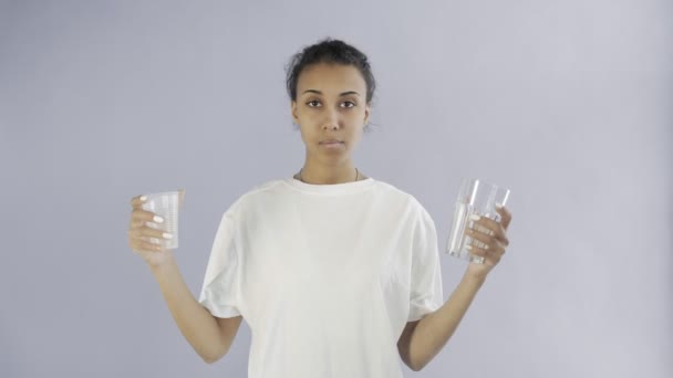 Afro-American Girl Activist Με πλαστικά και γυάλινα ποτήρια σε γκρι φόντο - Πλάνα, βίντεο