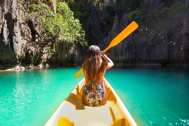 Woman kayaking in the Small Lagoon in El Nido, Palawan, Philippines - Travel blogger exploring south-east asia best places - Fotoğraf, Görsel