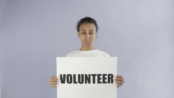 Afro-American Girl Activist With Volunteer Poster showing thumb up on grey background - Footage, Video